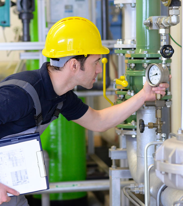 man-in-yellow-hard-hat-inspecting-gauge-nebb-building-formula-sheet